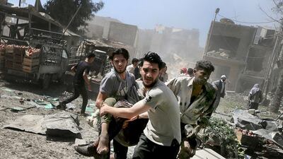 Men transport a casualty after what activists said were airstrikes by pro-regime forces on a busy marketplace in the Douma neighbourhood of Damascus on August 12, 2015. Bassam Khabieh/Reuters