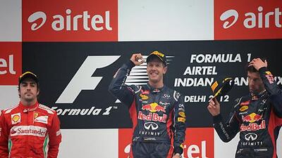 Sebastian Vettel atop the Indian Grand Prix podium, flanked by runner up Fernando Alonson and third placed Mark Webber.