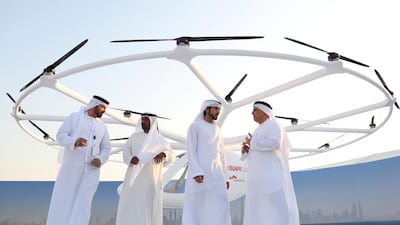 Sheikh Hamdan bin Mohammed, Crown Prince of Dubai, second right, stands in front of the flying taxi in Dubai. Satish Kumar / Reuters