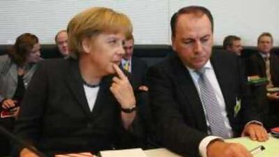 Angela Merkel, the German chancellor, and Axel Weber, the head of Bundesbank, attend a meeting in Berlin yesterday.