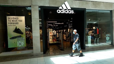 A shopper walks past an Adidas store in Miami, Florida. Adidas is reported to have reached an agreement to sell Reebok to Authentic Brands for nearly $2.5 billion. Photo: Getty Images
