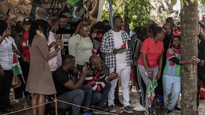 Kenyan climate activist Truphena Muthoni, right, is joined by supporters after setting the world record for hugging a tree, lasting 72 hours without eating or sleeping. AFP