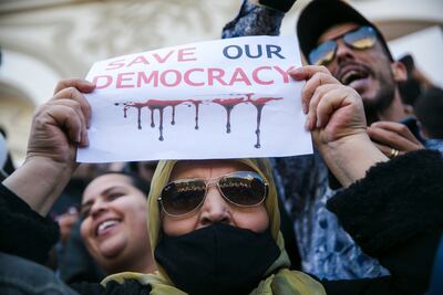 A woman holds up a banner during a protest against Tunisian President Kais Saied, in Tunis. AP