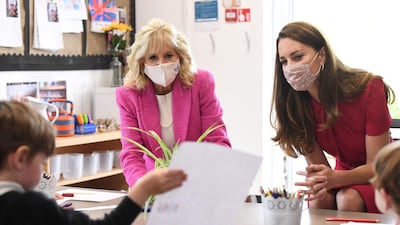 Catherine, Duchess of Cambridge and Jill Biden view a child's work during their visit. AFP