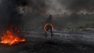 A Palestinian demonstrator holds a ring of fire during clashes with Israeli forces at a protest marking Land Day, near the Jewish settlement of Beit El, in the Israeli-occupied West Bank. Reuters