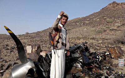A Houthi fighter stands by what the rebels say is a crashed US MQ-9 drone targeted by one of their missiles in Saada province. Getty