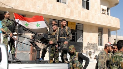 Syrian soldiers hold a flag in a street of Hteitit Al Turkman, a key town southeast of Damascus, after capturing it. Their weapons could be provided from several weekly flights from Tehran. Sana via AP