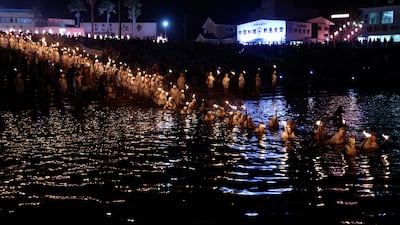 "Ama" female free divers, who harvest sea life from the ocean, lead volunteers as they swim with torches during Shirahama Ama matsuri in Minamiboso, Chiba Prefecture, Japan.