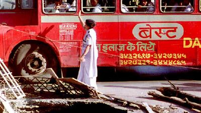 A double-decker bus passes a crater caused by one of a series of bombs that rocked the western port city of Bombay. AFP
