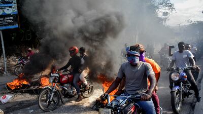 Motorcyclists join protests against Prime Minister Ariel Henry’s rule in Port-au-Prince, Haiti, as rubbish burns in the streets. EPA