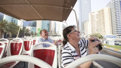 German tourists Joerg Lippert, 51, and his wife Ingert enjoy the ride aboard the Big Bus tour. The buses take passengers to 22 locations around Abu Dhabi. Mona Al Marzooqi / The National