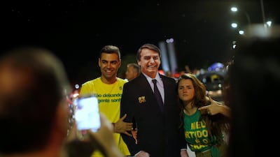 Supporters of Jair Bolsonaro pose with a cardboard cutout of Bolsonaro, in Brasilia. Reuters