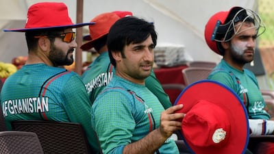 Afghanistan cricket team captain Asghar Stanikzai, centre, takes a break during a practise session at a cricket stadium in Greater Noida, India. Money Sharma / AFP