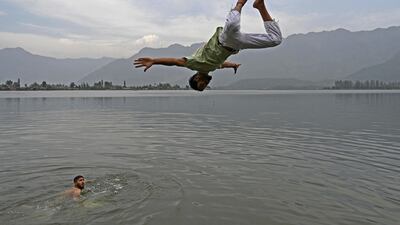A boy jumps into the waters of Dal Lake on a hot summer day in Srinagar in India-administered Kashmir. AFP