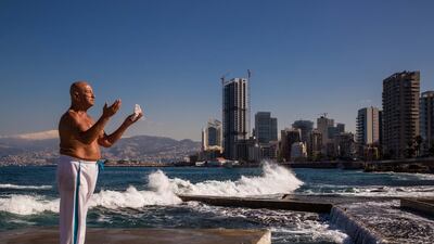 A photograph by Vianney Le Caer shows former crane operator Abu Khodor praying by the beach in Beirut, as he has done for the past 25 years. Courtesy Vianney Le Caer