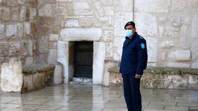 A Palestinian policeman stands in front of the closed door of the Church of Nativity ahead of Christmas in the biblical city of Bethlehem in the occupied West Bank. AFP