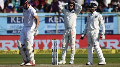 England captain Alastair Cook, left, watches as India captain Virat Kohli, centre, reacts after a shot during the fourth day of the second Test cricket matchat the Dr YS Rajasekhara Reddy ACA-VDCA Cricket Stadium in Vishakhapatnam on November 20, 2016. Prakash Singh / AFP