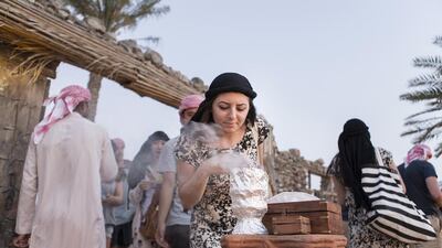 A woman draws in the scent of bukhoor at a desert camp site in Dubai. The tourism course will educate Emiratis in providing an ‘authentic experience’ to the visitors. Reem Mohammed / The National