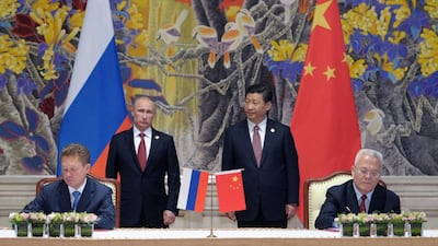 Russian and Chinese state energy company chiefs sign a supply agreement as the countries’ leaders look on. Alexey Druginyn / RIA Novosti