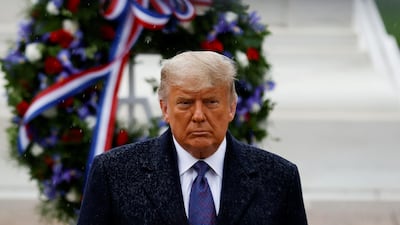 US President Donald Trump turns after placing a wreath at the Tomb of the Unknown Solider as he attends a Veterans Day observance in the rain at Arlington National Cemetery in Arlington, Virginia, US. Reuters