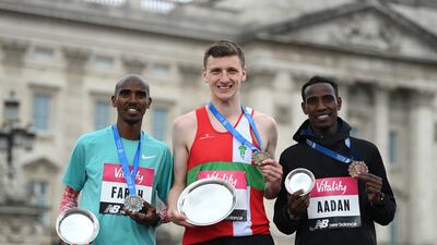 Race winner Ellis Cross, centre, second-placed Mo Farah, left, and Mohamud Aadan, right, on the podium in London. Getty