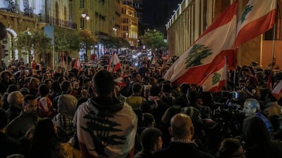 Protesters carry placards and wave Lebanese flags as they shout slogans against the parlianment members, during an anti-government protest in front of the Parliament building in Beirut. EPA