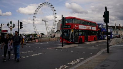 A double decker bus on Westminster Bridge, against the backdrop of the London Eye. AP