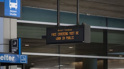A sign urges passengers to wear masks at Logan International Airport in Boston, Massachusetts. Bloomberg