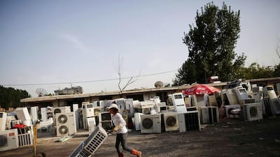 A recycling worker moves air-conditioning units in the yard of her tenement house at Dongxiaokou village. Kim Kyung-Hoon / Reuters