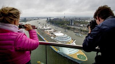 People take picture of the world's largest cruise ship Oasis of the Seas leaving the Rotterdam harbour. Robin Van Lonkhuijsen / AFP