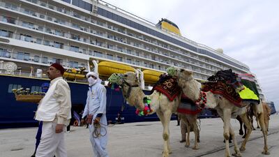 Men lead camels at the port of La Goulette in Tunis, as Tunisia welcomes the first cruise from Europe since 2019 due to the Covid-19 pandemic. AFP