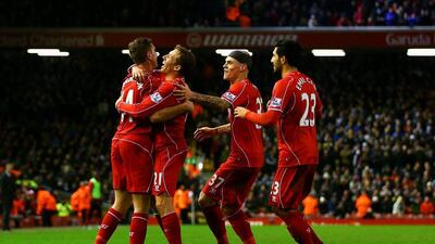 Jordan Henderson of Liverpool celebrates with teammates after Swansea City's Jonjo Shelvey scores an own goal in their Premier League contest on Monday night at Anfield. Clive Brunskill / Getty Images