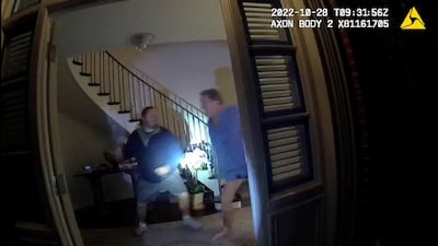 A screenshot from a police bodycam footage shows David DePape lifting a hammer to strike Paul Pelosi. Reuters