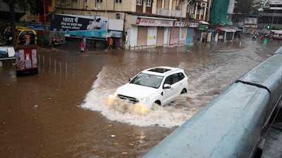 An Indian motorist pushes through a flooded street after heavy rainfall left by cyclone Tauktae's journey through the city of Mumbai. EPA