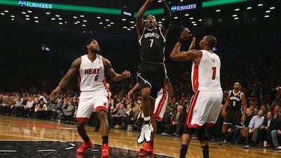 Joe Johnson, centre, of the Brooklyn Nets shoots against LeBron James, left, and Chris Bosh of the Miami Heat during their game in New York City on Friday night. Al Bello/Getty Images