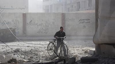 A man pushes a bicycle as he makes his way through rubble in the eastern Damascus suburb of Ghouta last week. Ammar Al Erbeeni / Reuters