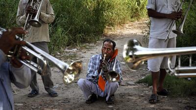 Members of Master Band, an Indian Brass band, specialized playing in weddings, rehearse on the bank of the river Yamuna, in New Delhi.