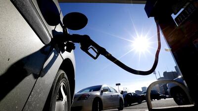 Vehicles form a line behind a motorist re-fueling at a gas station. Julio Cortez / AP Photo