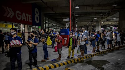 Commuters queue at a bus station in Parañaque, Metro Manila. Getty Images