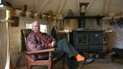 Mark Wilkinson in the garden house he designed for his home. The twist candlestick (far left) is his signature design.