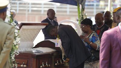 Mourners pay their last respects at the coffin of former Zimbabwean President Robert Mugabe at the Rufaro Stadium in Harare, where the body is on view at the stadium for a second day. Mugabe died last week in Singapore at the age of 95. He led the southern African nation for 37 years before being forced to resign in late 2017. AP Photo