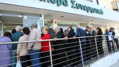 People wait in a long queue outside a branch of the COOP Bank in Nicosia, Cyprus. All of the country's 26 banks were open from 12pm until 6pm yesterday.