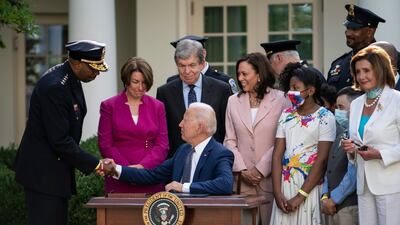 US President Joe Biden shakes hands with Robert Contee III, Chief of the DC Metropolitan Police Department, after signing the bill into law at the White House. EPA