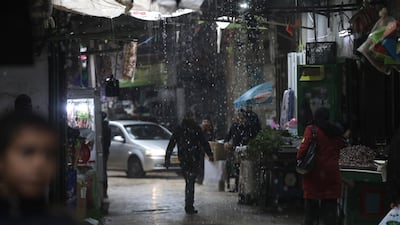 Palestinians walk at a street during a rain storm in the Old City of Nablus, West Bank. EPA