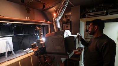 Tariq Al Shawa, manager of the Holst Park and Cultural Centre in Gaza City since 1998, inspects its projector as the venue undergoes renovation. Majd Mohamad for The National