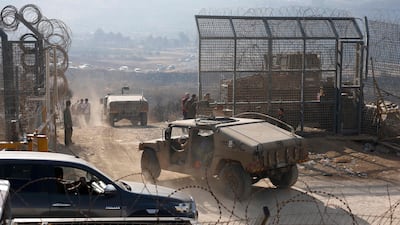 Israeli troops stand guard as members Syria's Druze community approach a fence near the Golan Heights. AFP
