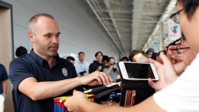 Andres Iniesta signs an autograph for a fan upon arrival at Kansai International Airport. Shohei Miyano / AP Photo
