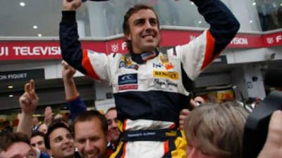 The Renault Formula One driver Fernando Alonso of Spain celebrates with his team after winning the Japanese F1 Grand Prix at Fuji Speedway in Oyama on Oct 12 2008.