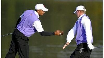 Tiger Woods, left, celebrates with partner Steve Stricker during the opening round of fourballs at Celtic Manor golf course in Wales yesterday.
