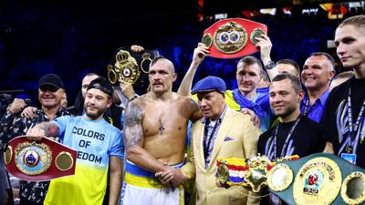 Oleksandr Usyk celebrates with his belts and his team. Getty